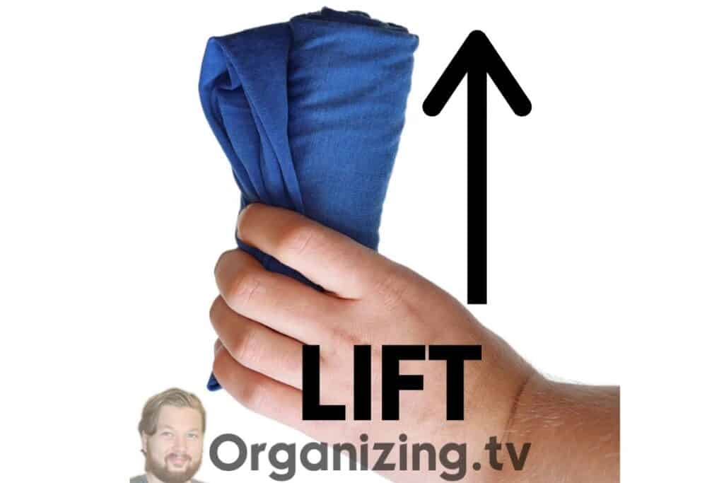 lifting up the rolled shirt with one hand