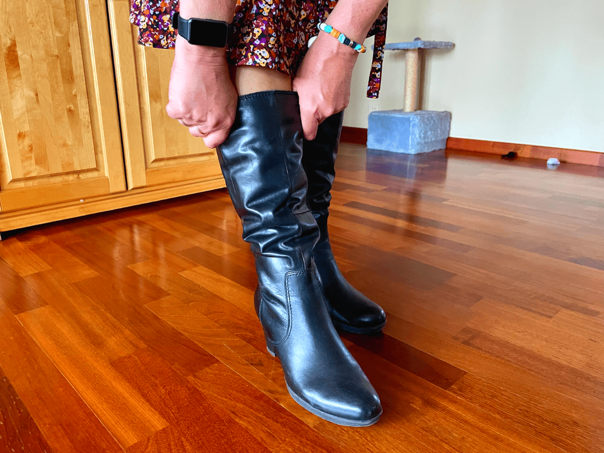 Woman pulling up boots that have fallen down around her calves