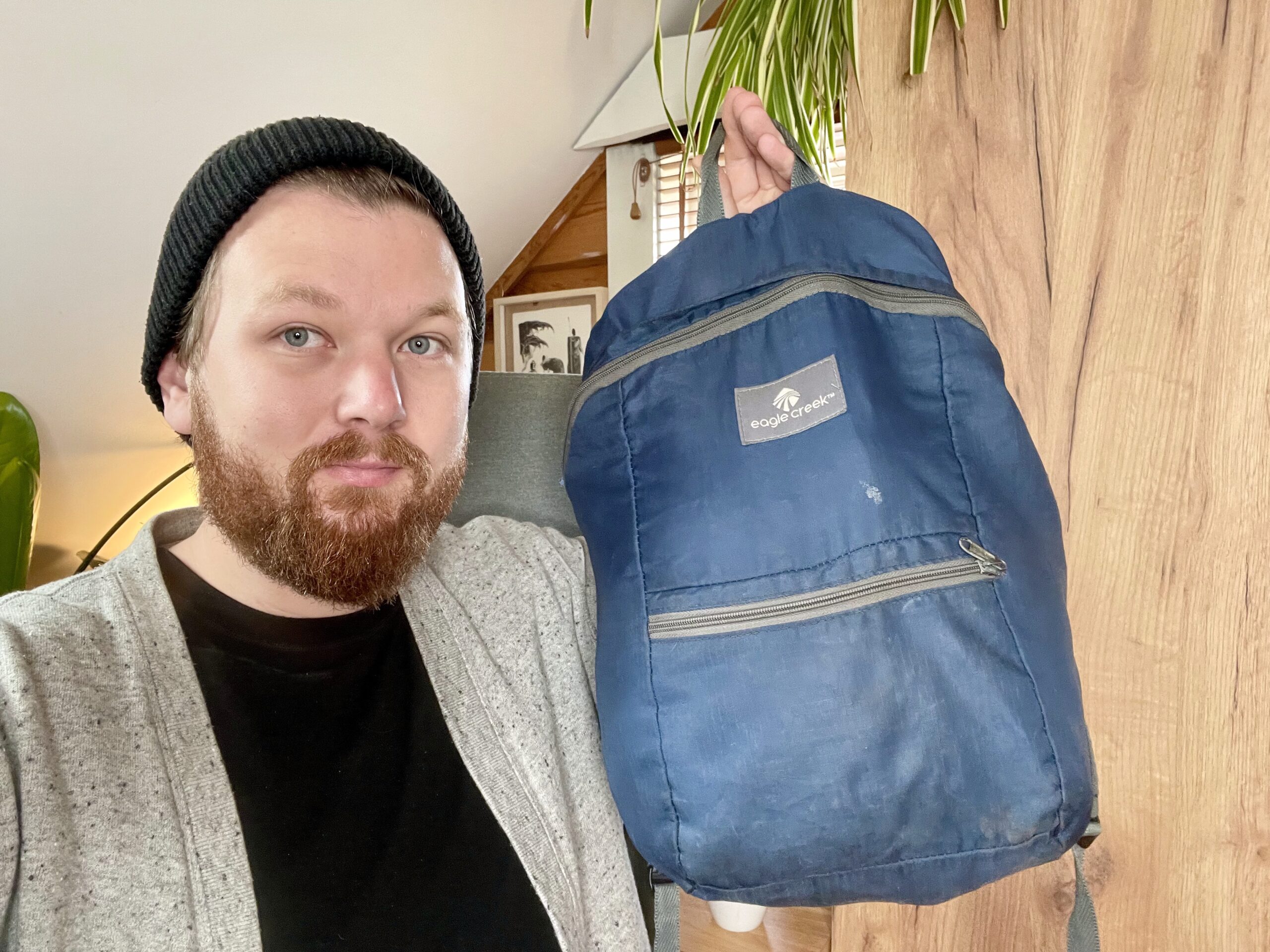 Tor holding the blue backpack he bought in 2014 and traveled the world with until 2019