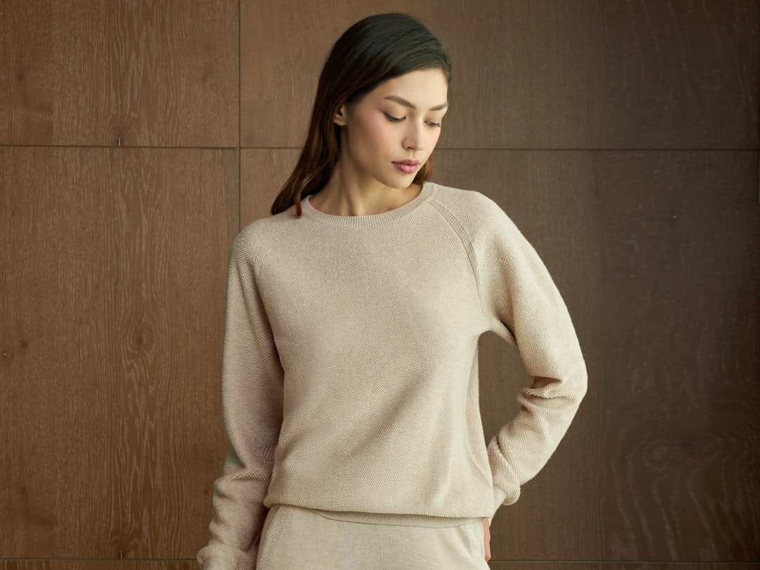 Woman wearing a beige crew neck top with a smooth neckline that completely covers bra straps, demonstrating how choosing the right top prevents strap visibility