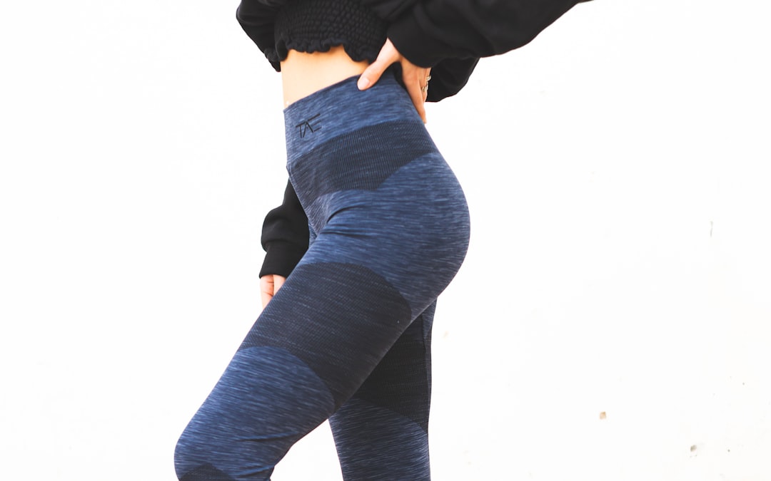 Woman wearing high-waisted blue compression leggings showing how athletic wear follows and flatters the butt shape
