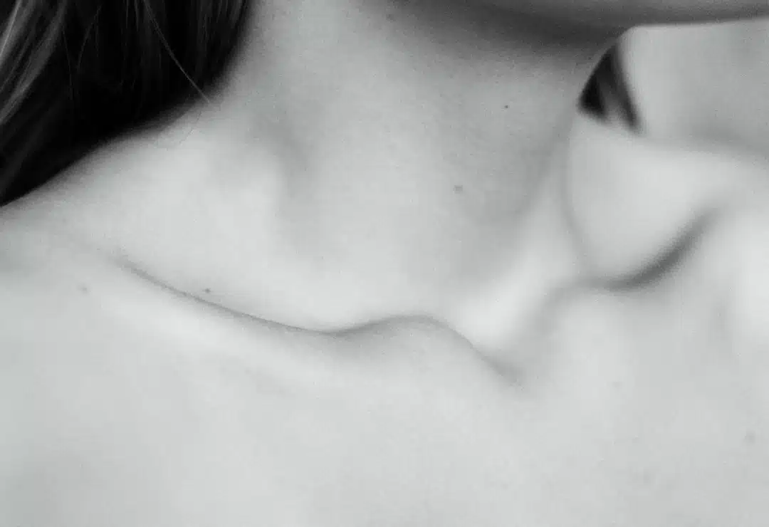 Woman wearing a wide neckline top that frames the collarbone area, showing how the right neckline makes collarbones the focal point