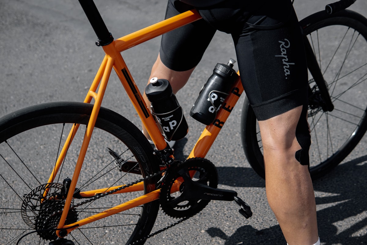 Close-up of a cyclist's legs wearing bike shorts while pedaling a road bike