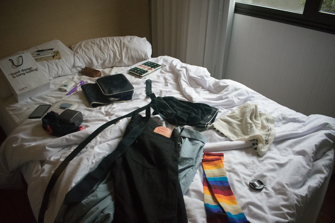 Clothes, toiletries, and personal items spread across a bed during packing, showing the chaotic result of common packing mistakes