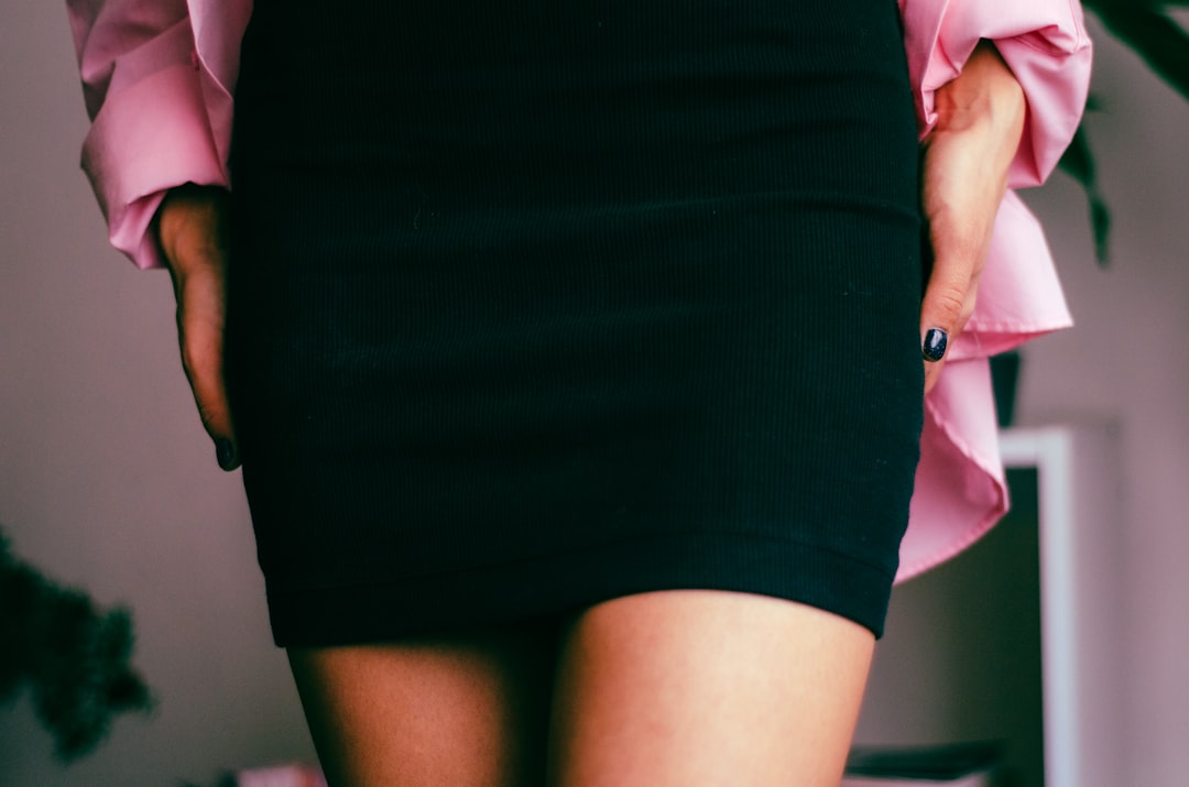 Close-up of woman wearing fitted black skirt showing hip and thigh area