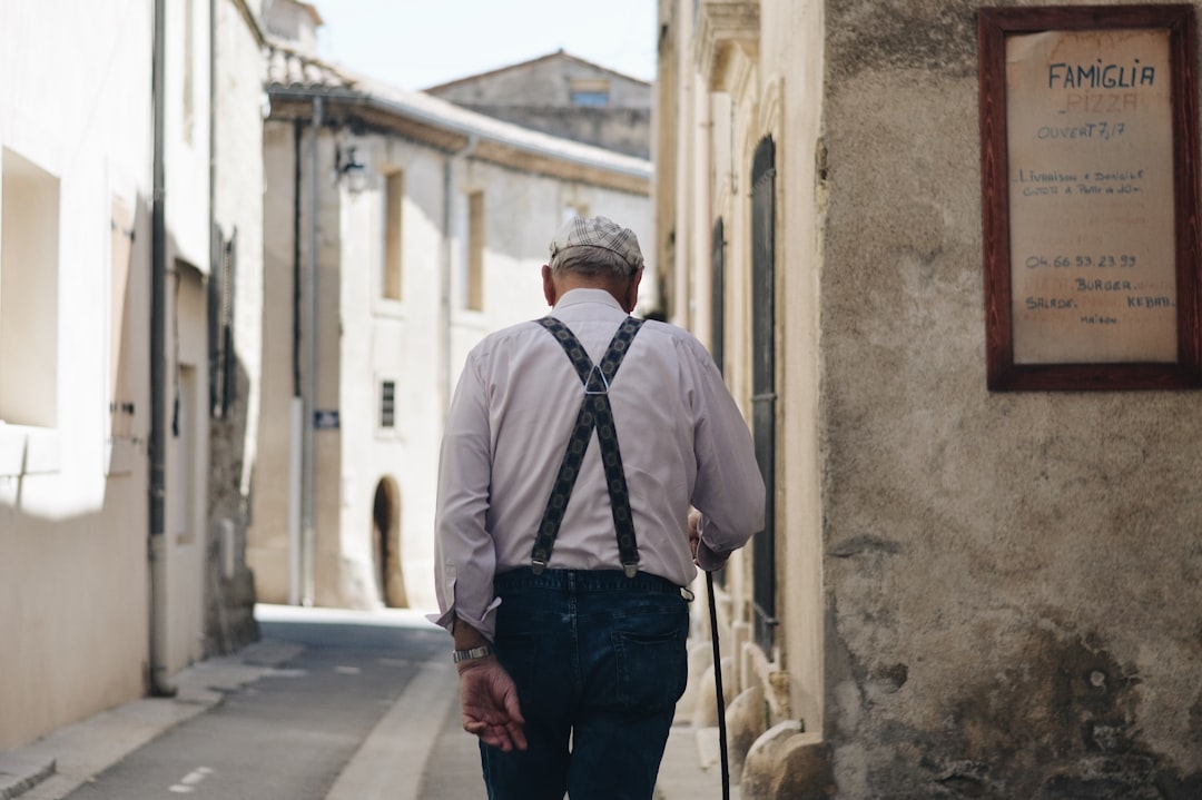 Man wearing suspenders over a white shirt showing how suspenders hold pants up from the shoulders to prevent them from sliding down