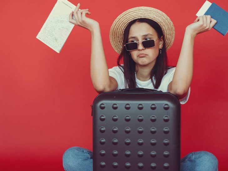 Woman looking confused with suitcase and travel documents not knowing where to begin packing
