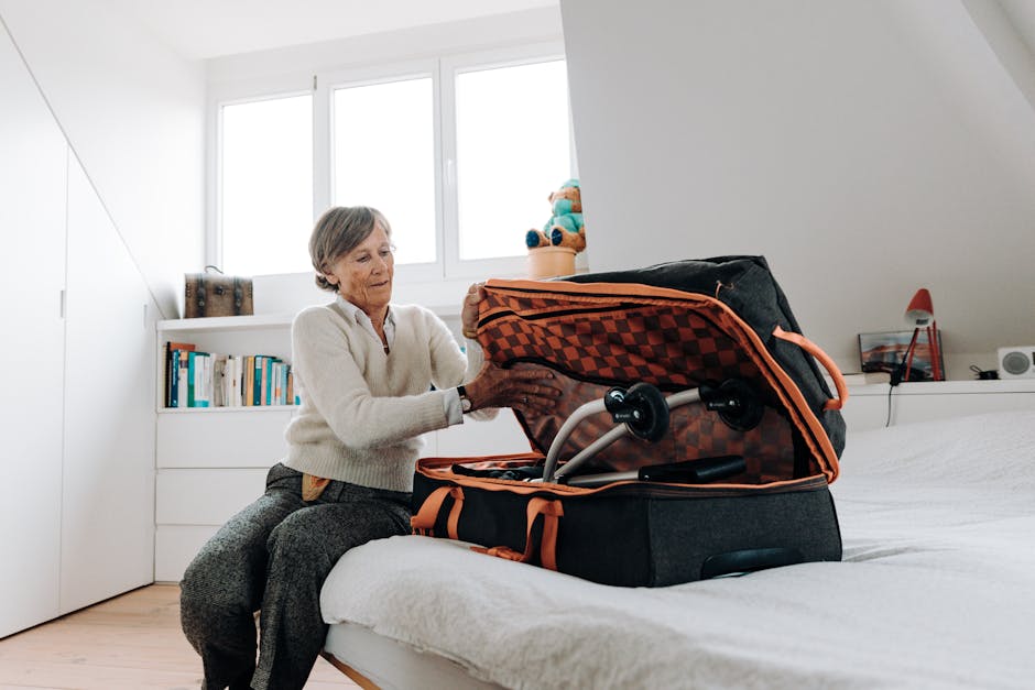 Older woman packing a travel capsule wardrobe into a suitcase