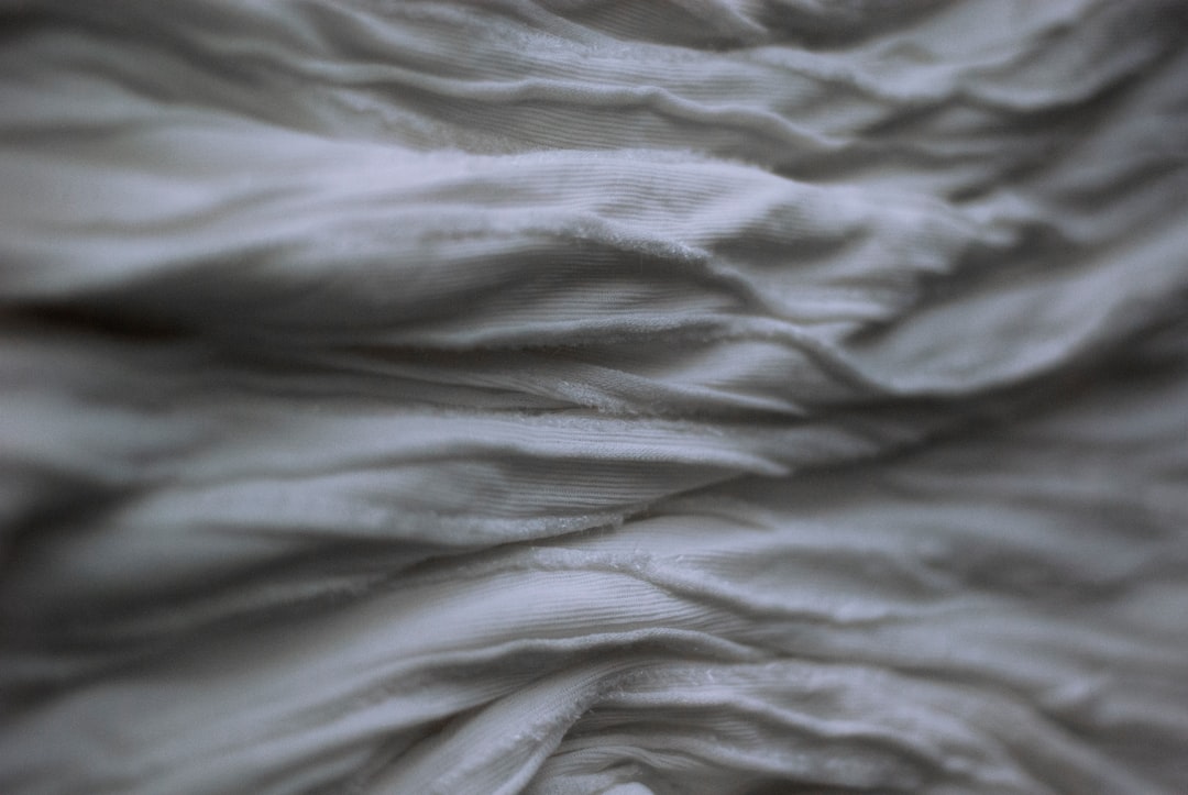Close-up of ruched fabric with gathered folds that create texture across the chest area making size differences impossible to detect